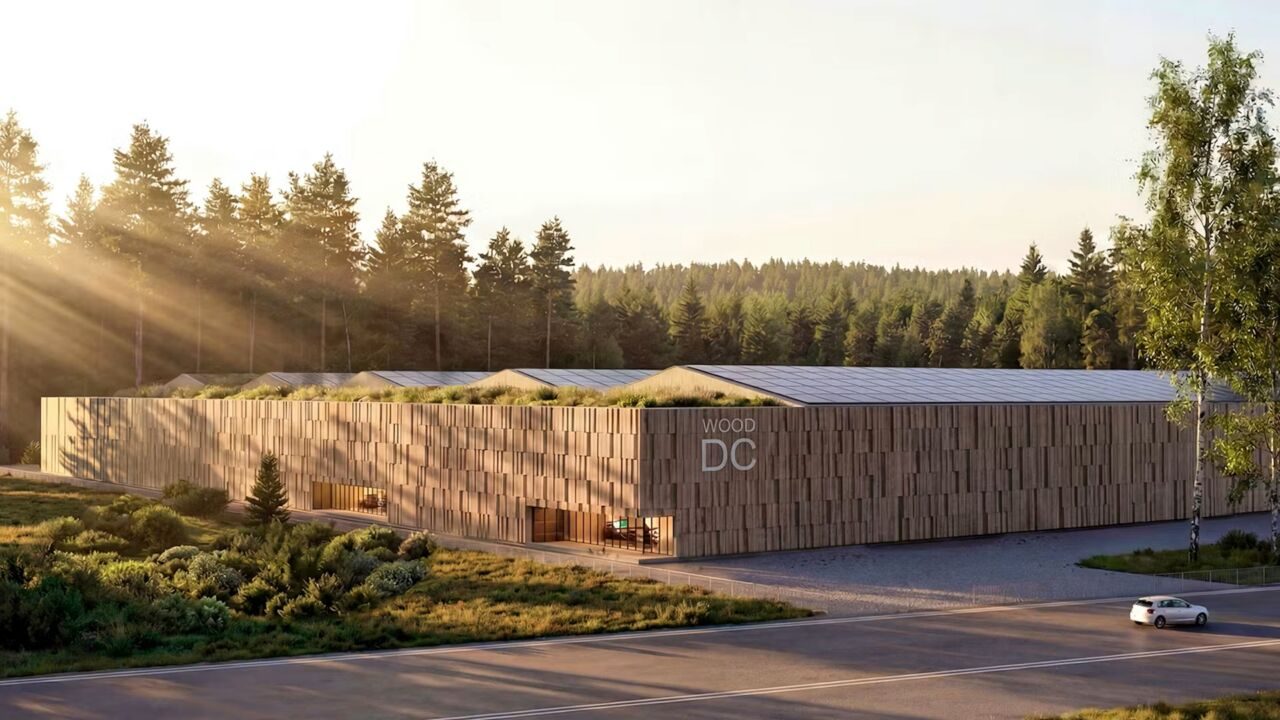 Architectural rendering of a timber-clad data center with a green roof and solar panels, set against a Nordic pine forest in evening light.